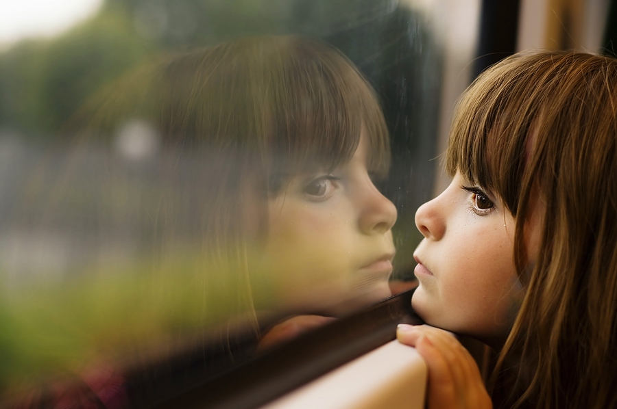 Girl looking through window 7422432